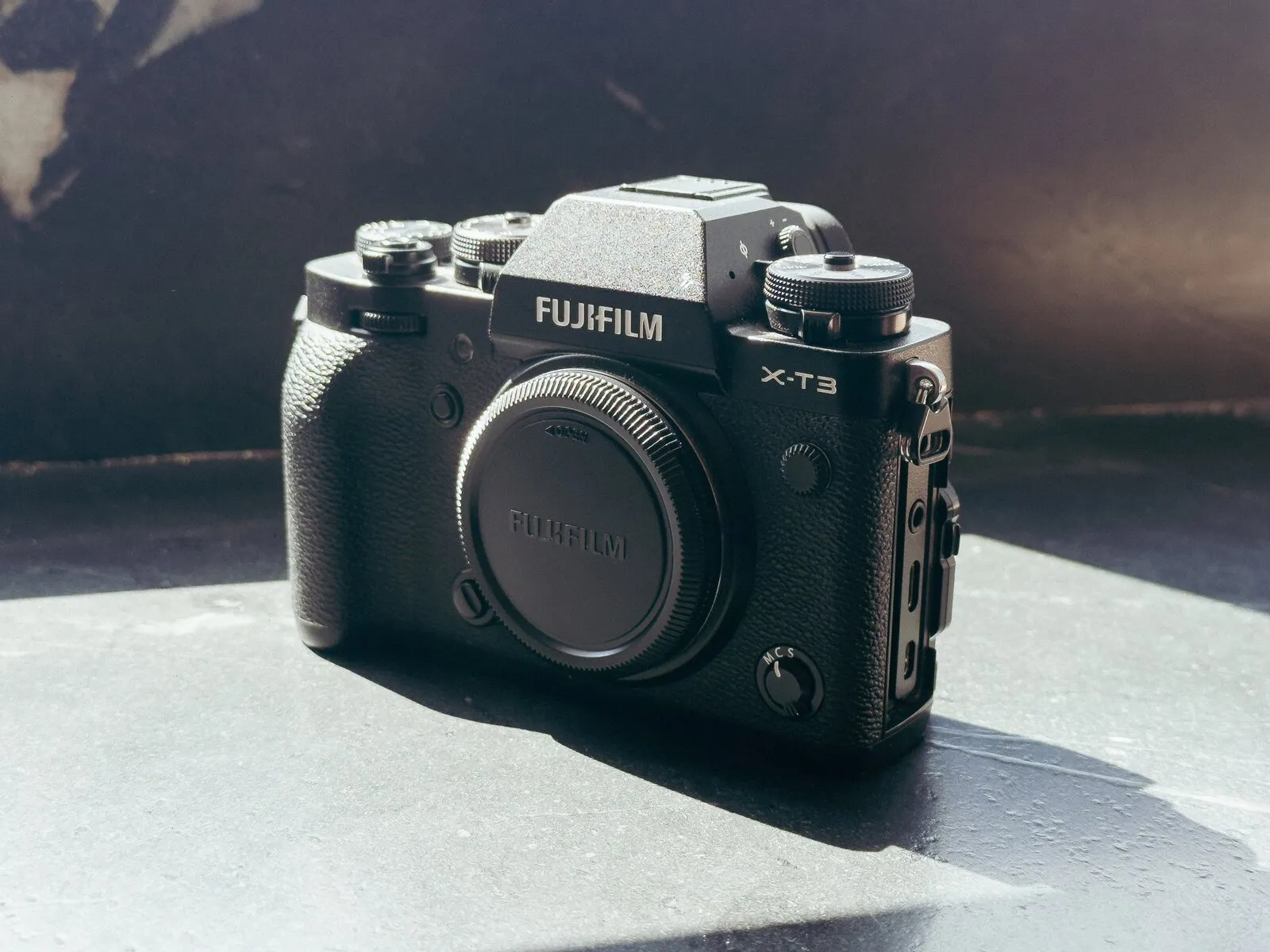 Fujifilm X-T3 - מצלמת מירורלס רטרו בעיצוב שחור על משטח אבן